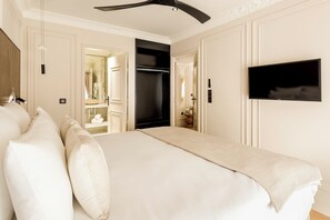 Een hotelkamer met een groot bed, een aan de muur bevestigde televisie en een kledingkast.