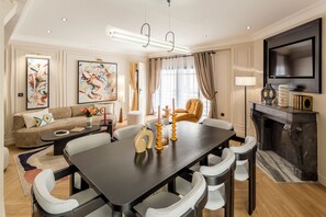 Een moderne woonkamer met een eettafel, banken en een open haard.