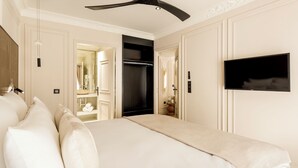 Une chambre d’hôtel avec un grand lit, un téléviseur fixé au mur et une armoire.