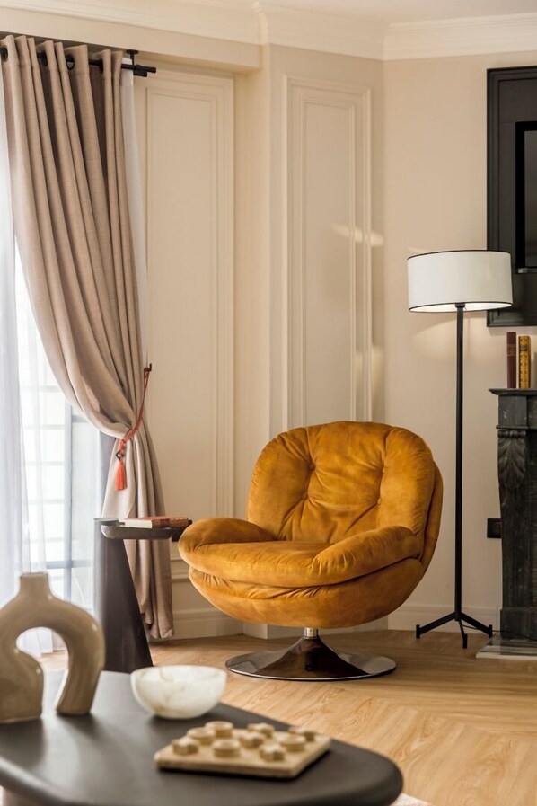 A modern living room with a mustard-colored armchair, a small side table, and a floor lamp.