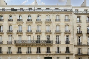 A multi-story building with a classical architectural style, featuring evenly spaced windows and ornate balconies.