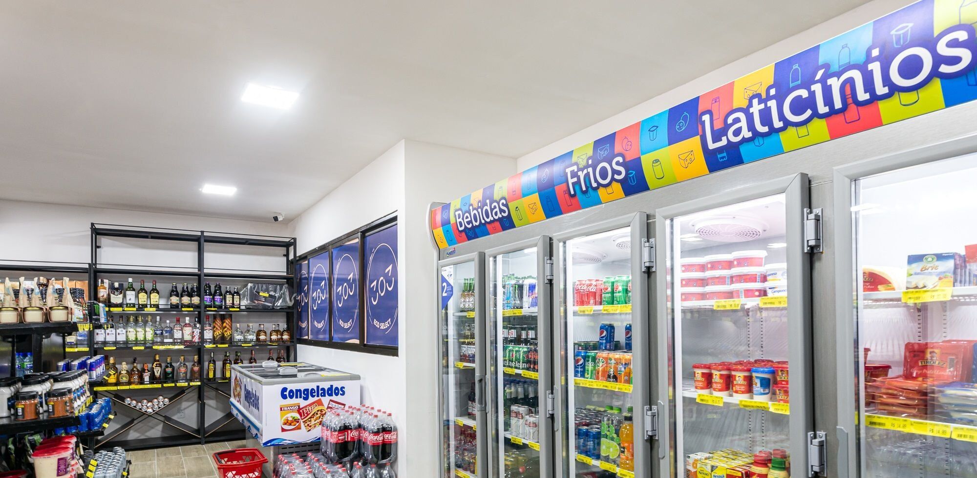 A grocery store with refrigerated sections labeled 'Bebidas' and 'Latiticiños'.