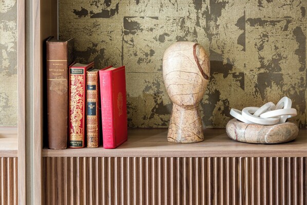 Una estantería de madera con libros y un objeto decorativo de cerámica.