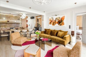 A modern living room with a sofa, chairs, a coffee table, and a dining area.
