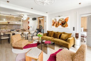 A modern living room with a sofa, chairs, a coffee table, and a dining area.