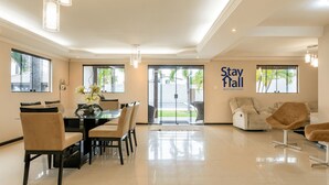 Un hall d’hôtel moderne comprenant un espace repas, des sièges et un panneau indiquant « Espace détente ».