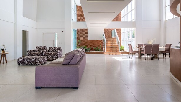 A spacious lobby with a modern staircase, a seating area with patterned sofas, and a dining setup. - Mansion with Private Pool and Jacuzzi 6 suites-082M (ipojuca)