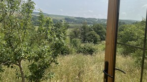 A view from a room with a wooden door, overlooking a lush landscape with trees and rolling hills. - Owls Nest - Alfriston East Sussex (Polegate)