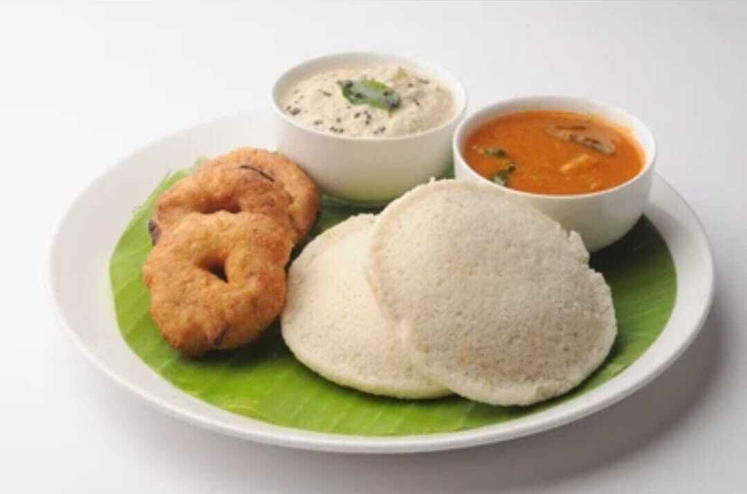 Un plato con dos idlis, una dosa y dos tipos de chutney.