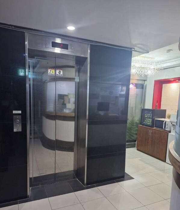 A modern elevator with a digital display, a control panel, and a glass door. - Yeon Stay (Seoul)