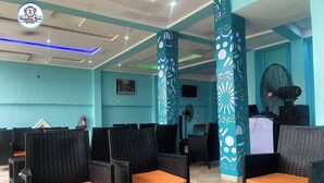 A seating area with wicker chairs and a fire extinguisher on the wall. - SummerTym Hotel & Suites  (Lekki)