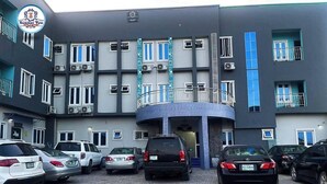 A multi-story building with a parking area in front. - SummerTym Hotel & Suites  (Lekki)