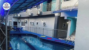 An indoor swimming pool with a blue and white color scheme, surrounded by a covered area with a metal railing. - SummerTym Hotel & Suites  (Lekki)