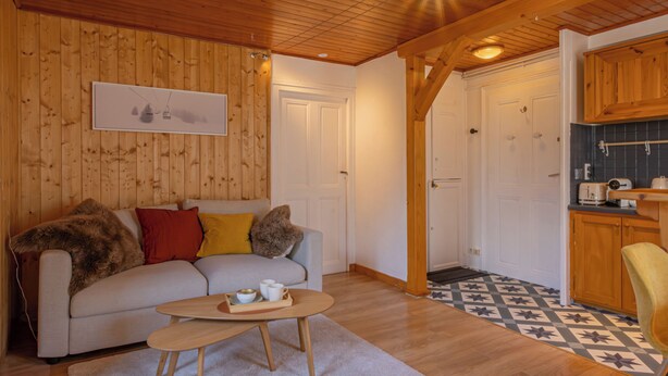 A cozy living room with a sofa, coffee table, and a patterned floor. - Rimaye Blanche - A bright and cozy 1 bed apartment. (Chamonix-Mont-Blanc)