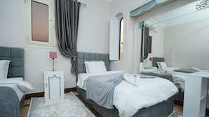 Un dormitorio moderno con una cama grande, una mesita de noche, un espejo y una ventana con cortinas.