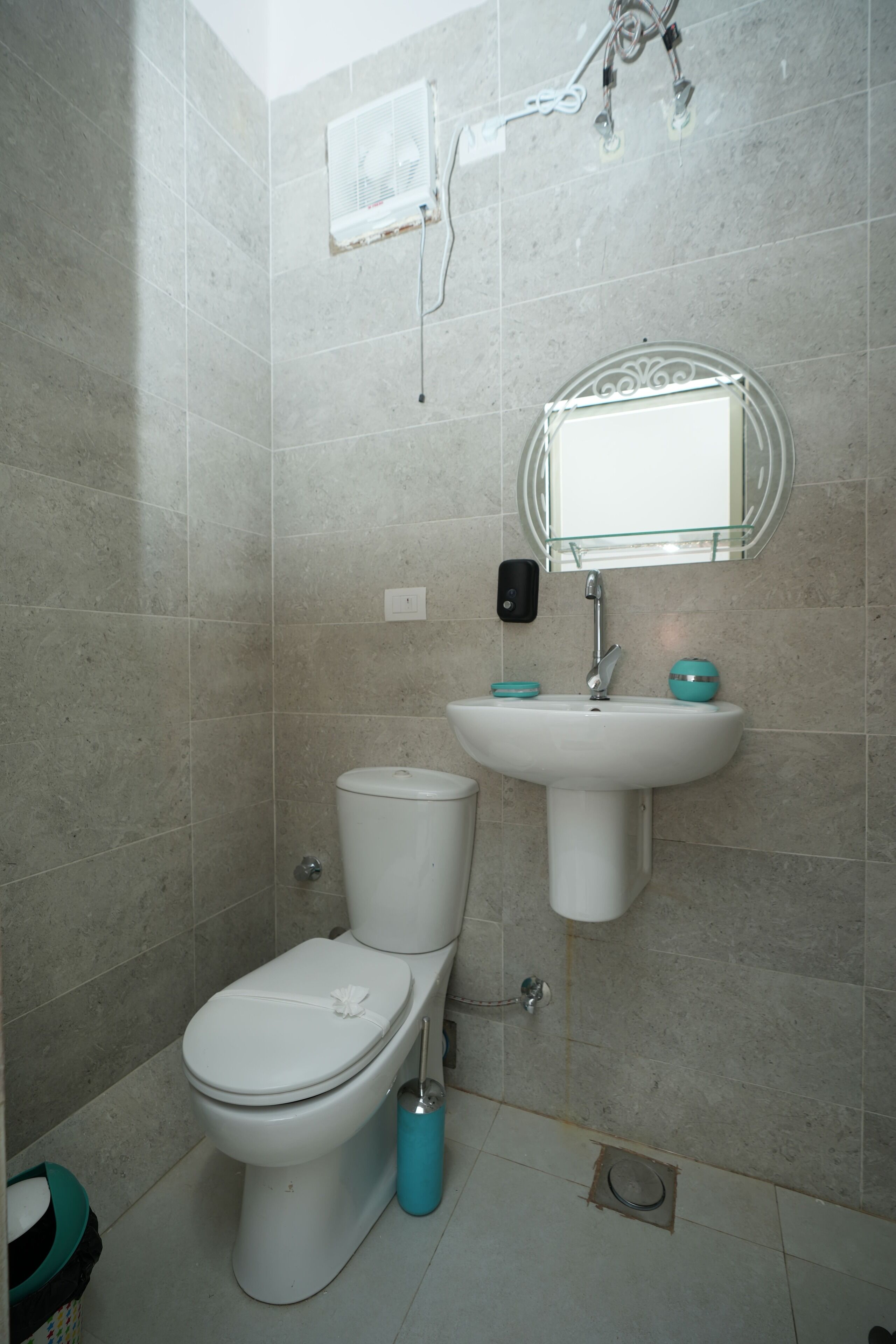 Une salle de bain avec des toilettes, un lavabo et un miroir.
