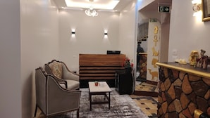 Un vestíbulo moderno con un banco de madera, una mesita y una pared de acento de piedra.