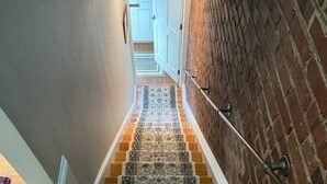 A staircase with patterned carpets and wooden steps. - Old Town Gem – Steps to Cafés, Shops & Metro! (Alexandria)