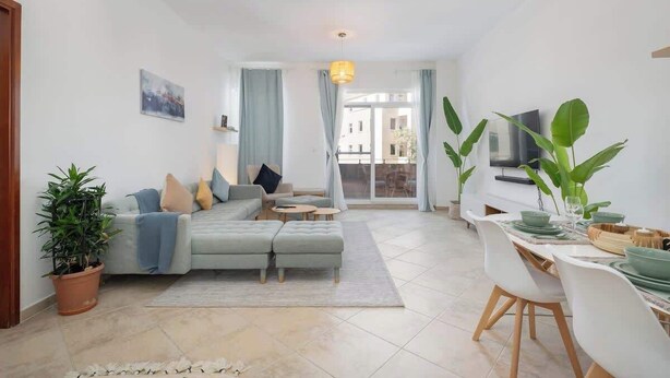 Una sala moderna con sofá, mesa de centro y comedor.