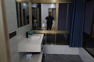 Un baño moderno con un lavabo blanco, un espejo y una zona de ducha.