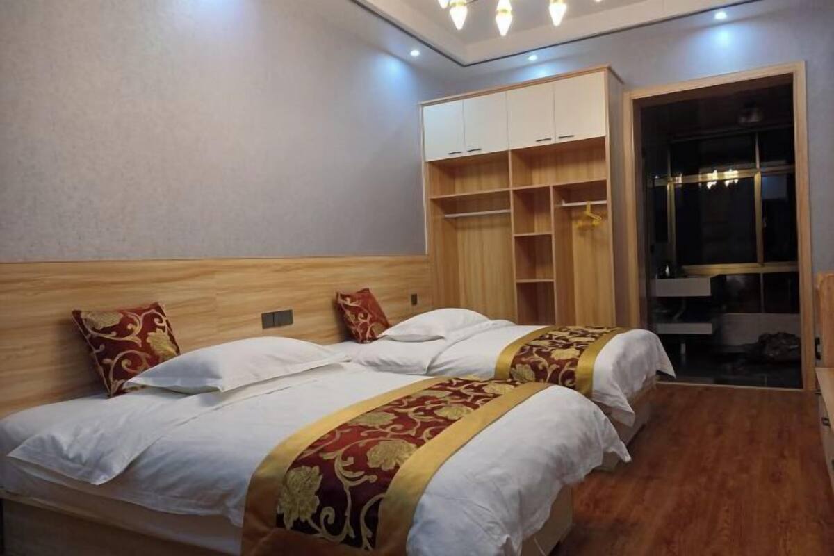 A bedroom with two beds, a wardrobe, and a built-in closet.