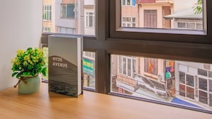 A view through a window with a potted plant and a sign reading "HYDE AVENUE". - Lotus Land Apartment (Hanoi)