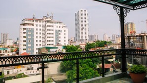 A balcony with a view of a cityscape, including high-rise buildings and construction cranes. - Lotus Land Apartment (Hanoi)