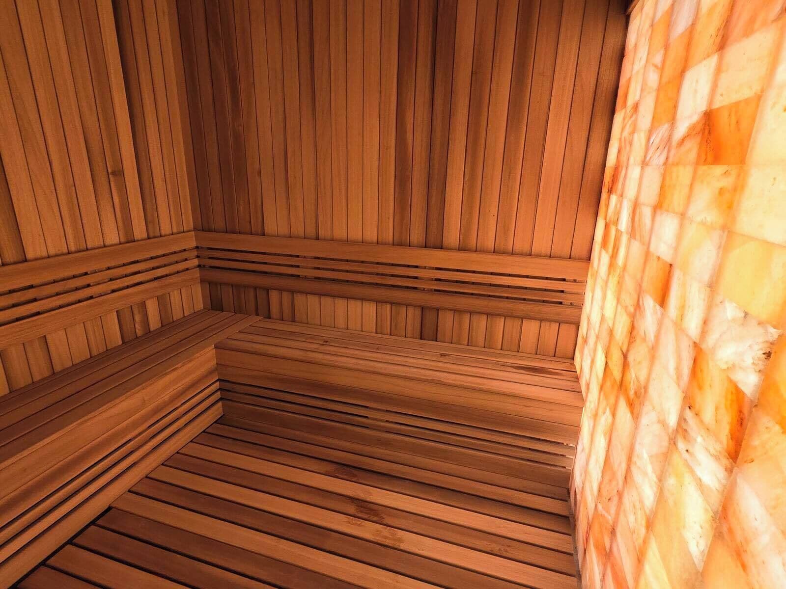 Una sauna amb seients de fusta i un mur a escacs.