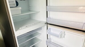 Un réfrigérateur en acier inoxydable doté de plusieurs tiroirs transparents et d’un compartiment congélateur.