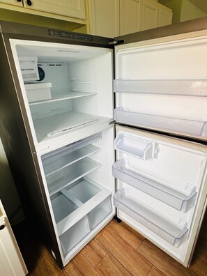 Een roestvrijstalen koelkast met meerdere glazen lades en een vriesvak.