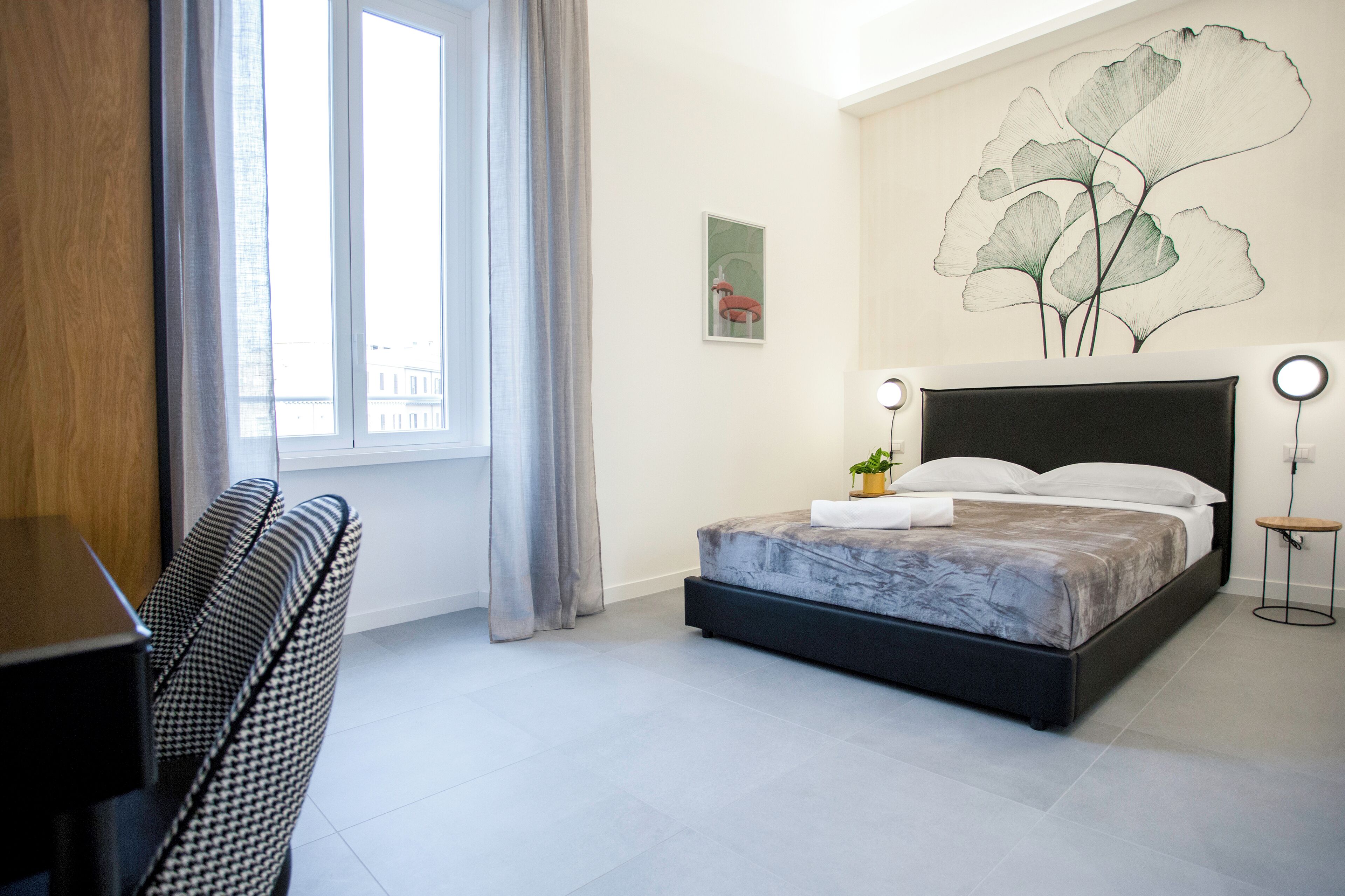 Une chambre moderne avec un lit, un bureau et une grande fenêtre avec des rideaux.