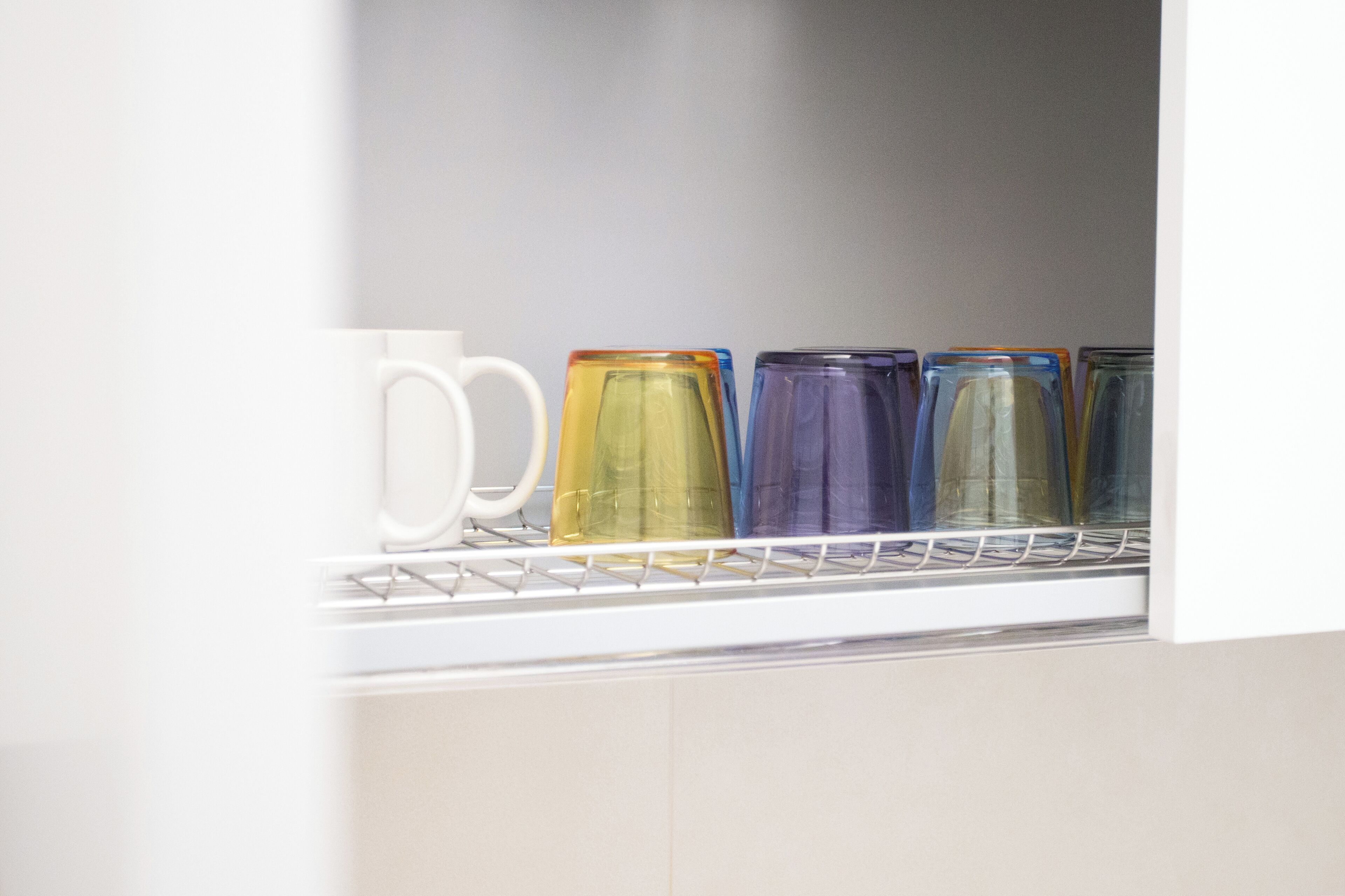 A shelf with colorful glass containers, likely for storage or decoration.