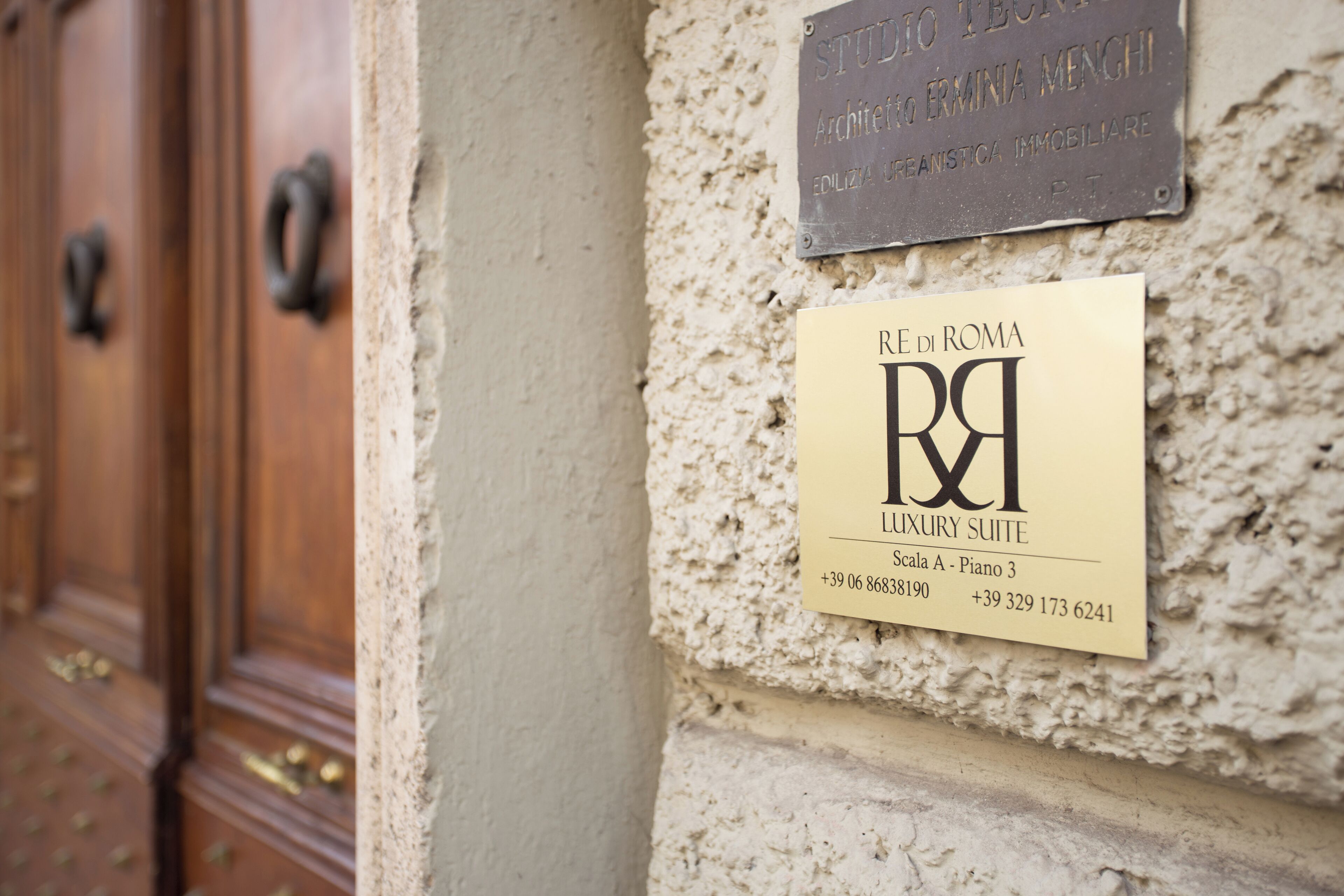 Une enseigne indiquant une suite de luxe, avec les coordonnées et une plaque au-dessus.