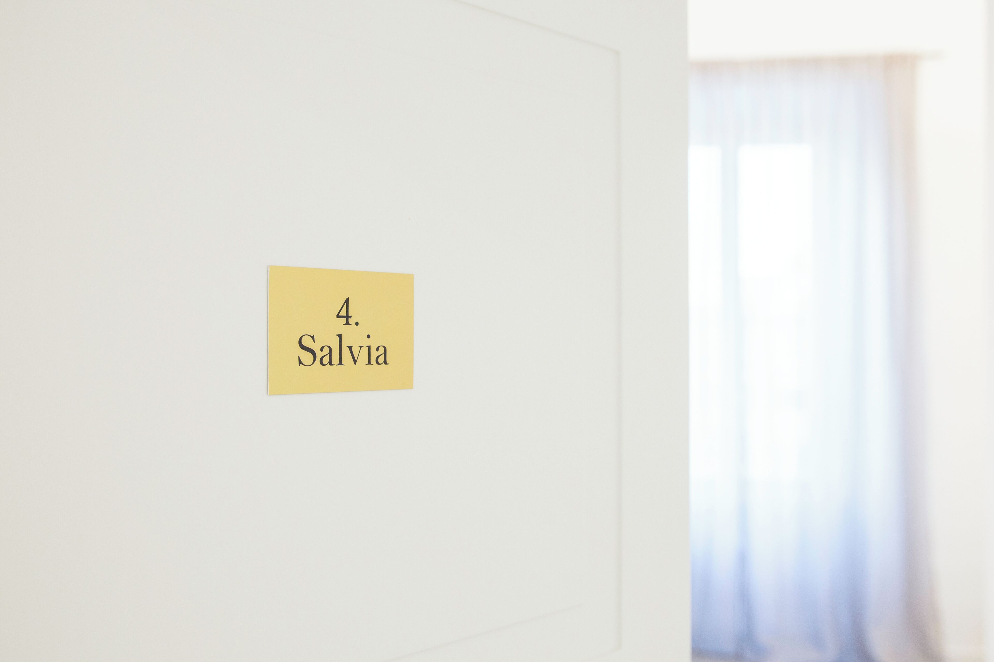 Eine Wand mit einem gelben Schild, auf dem '4. Salvia' steht.