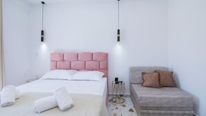 Une chambre à coucher moderne avec un lit, une table de chevet et un canapé.