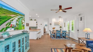 A spacious kitchen with a large island, a dining area with blue chairs, and a view of a coastal landscape through a large window. - P88 -  New on the rental market! 3 bedroom, 2 bath with private pool and 50 feet of dockage (Marathon)