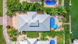 A residential property with a large house, two swimming pools, and a well-maintained garden with various plants and a dock. - P88 -  New on the rental market! 3 bedroom, 2 bath with private pool and 50 feet of dockage (Marathon)