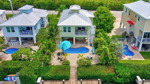 A residential area with two houses, a swimming pool, and a dock. - P88 -  New on the rental market! 3 bedroom, 2 bath with private pool and 50 feet of dockage (Marathon)