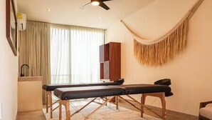 A room with a massage table, a ceiling fan, and a large window with curtains. - Increíble Nueva Suite con Balcón 2Pax | Tulum (Tulum Municipality)