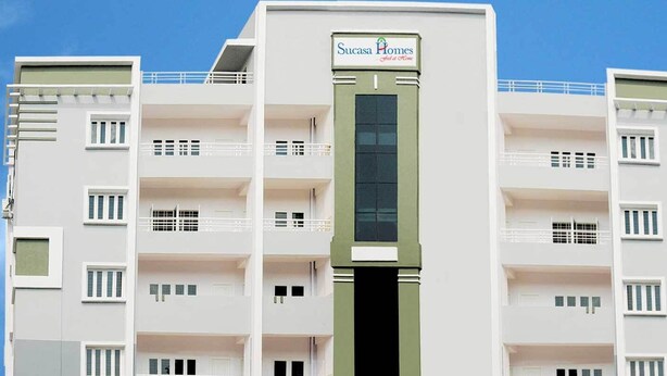 A multi-story building with a sign reading "Sucasa Homes." It has multiple balconies and windows on each floor. - Sucasa Homes (Hyderabad)