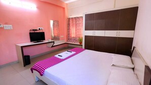 A bedroom with a bed, a desk, a television, and a wardrobe. - Sucasa Homes (Hyderabad)