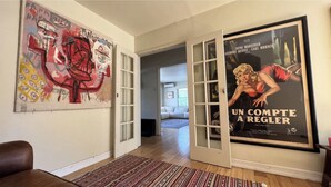 A room with a large poster, a sofa, and a patterned rug. - Santa Monica 3 bedroom house with sunny outdoor deck (Los Angeles)