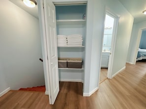 Un armario vestidor con repisas para ropa doblada y cajas de almacenamiento.