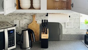 Eine Küche mit Mikrowelle, Wasserkocher und einem Messerblock.