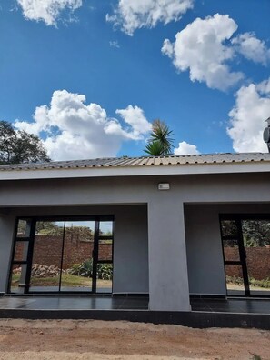 A building with large windows and a flat roof, viewed from the ground.