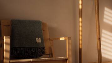 A wooden chair with a tag, a wooden table, and a wall with a wooden post.