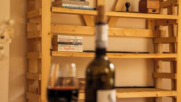A wooden bookshelf with books and a wine bottle.