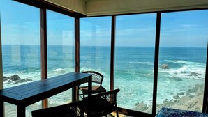 A room with a large window overlooking the ocean, a table, and a chair. - NEW LISTING! OCEANFRONT CORNER TOP FLOOR 2 BEDROOM UNFORGETTABLE VIEWS
 (San Lucas)