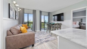 Un apartamento moderno con sala de estar, comedor y balcón con vista a la ciudad.