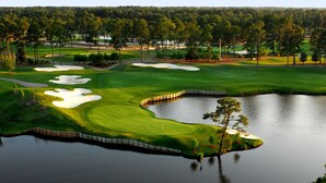 A golf course with sand bunkers, water hazards, and a pond.